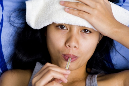 Young woman with thermometer in mouth having Rat-Bite Fever